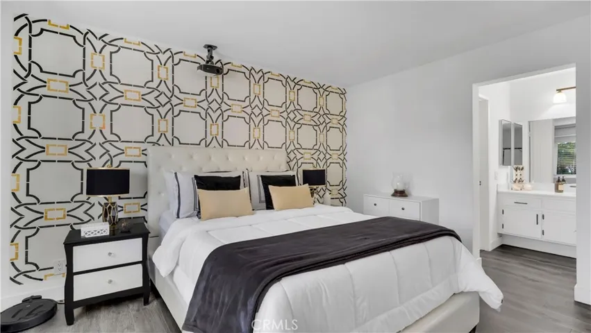 In the primary bedroom, a hand-stenciled designer accent wall adds a unique artistic touch you won’t see in other homes.
