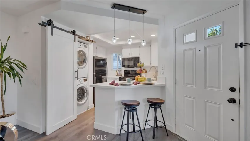 The stackable washer and dryer are included and can easily be tucked away by a barn style door.