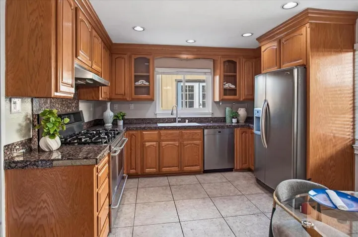 Spacious kitchen with granite counters, stainless steel appliances, and gas cooking.