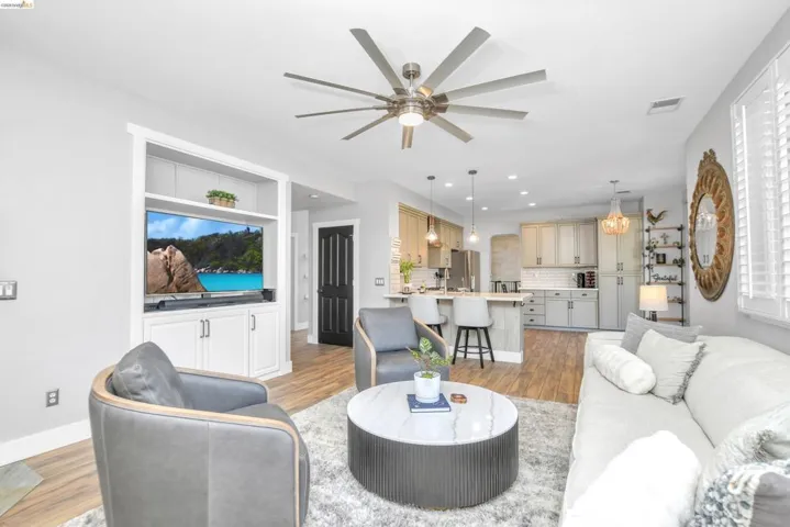 Living area with a ceiling fan and light wood-style floors