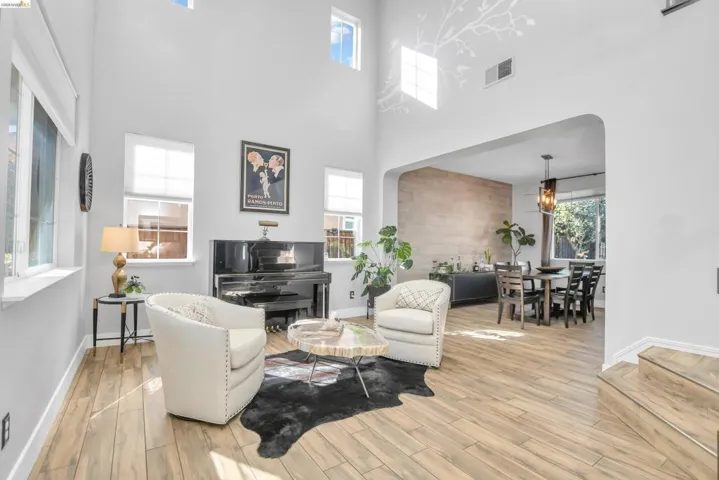 Living area featuring arched walkways and light wood-type flooring