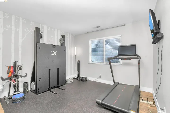 Workout room with baseboards and wallpapered walls