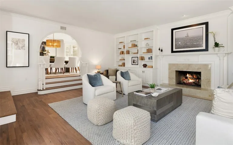 Living room with walnut hardwood floors and wood burning fireplace with gas starter
