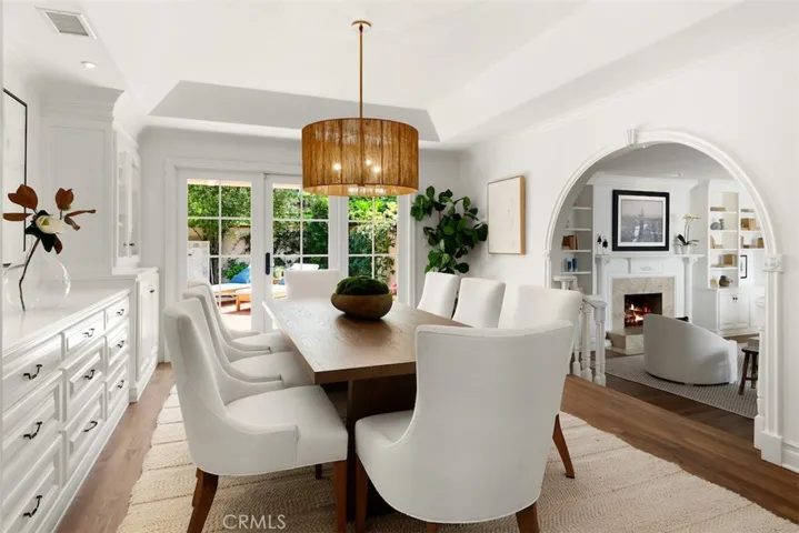 Formal dining room with custom built-in cabinets with glass fronts and lights. Open to large patio with calming fountain