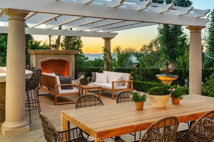 Patio off kitchen/family room with fireplace, view, bar with built-in BBQ and storage