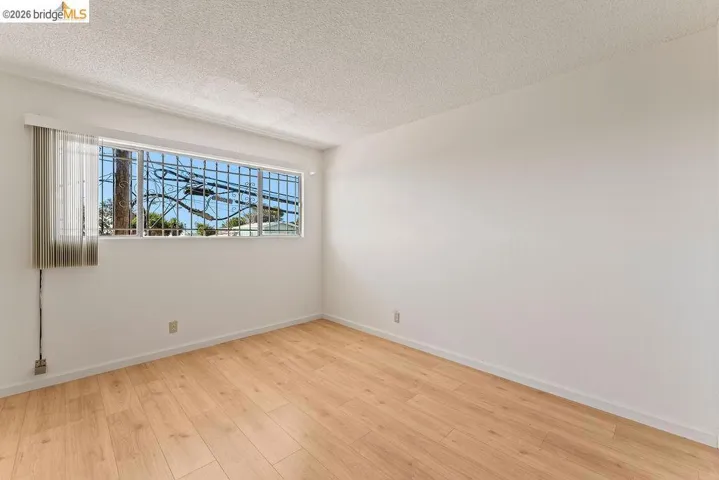 Unfurnished room with light wood-style floors and a textured ceiling