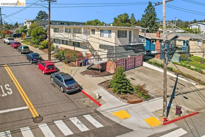 View of asphalt street featuring sidewalks, curbs, and street lights
