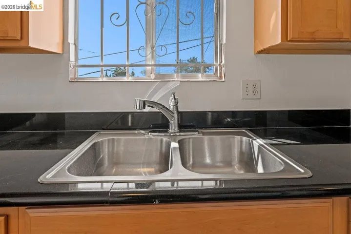 Kitchen view of a sink and light wood finish cabinets