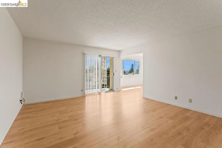 Unfurnished room with a textured ceiling and light wood finished floors
