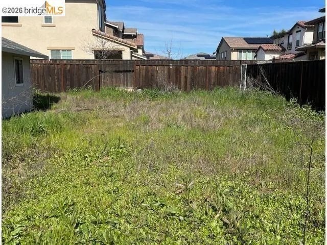 Fenced backyard featuring a residential view