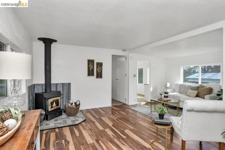 Living room with wood finished floors and a wood stove
