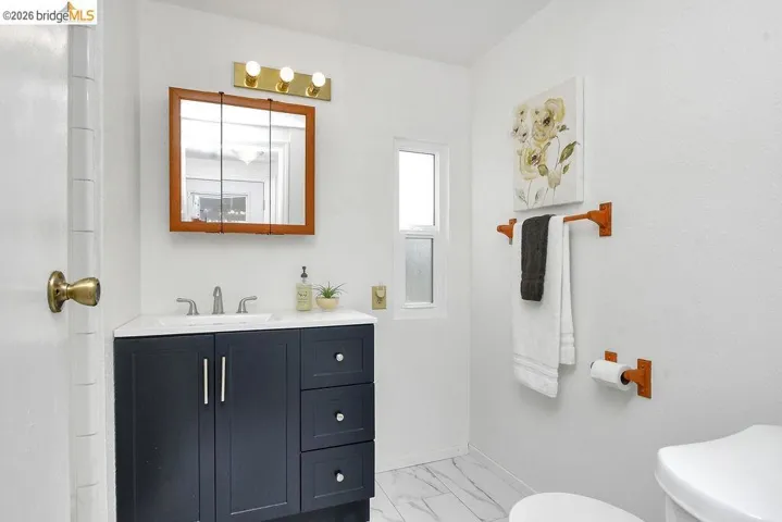Bathroom with vanity and light marble finish flooring