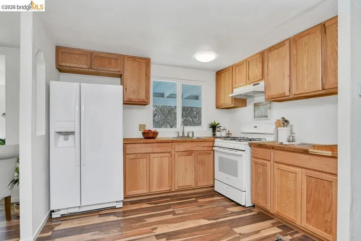 Kitchen featuring white appliances, light wood-style flooring, and light wood finish cabinetry