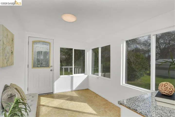 Unfurnished sunroom with baseboards