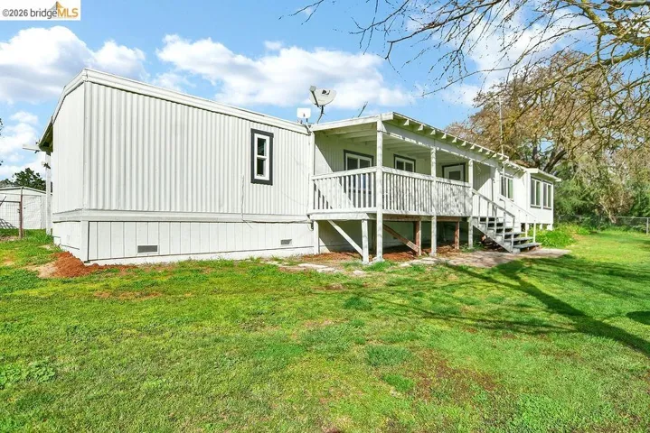 Rear view of house with crawl space and a yard