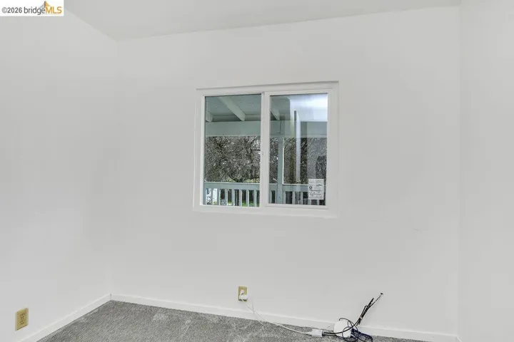 Spare room with carpet and baseboards