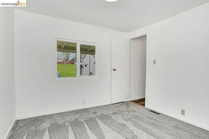 Unfurnished room with carpet flooring and baseboards