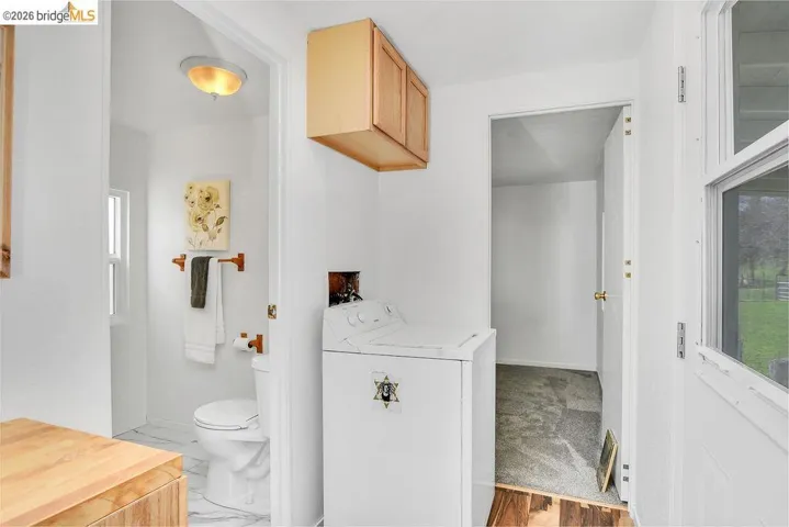 Half bath featuring washer / dryer and toilet