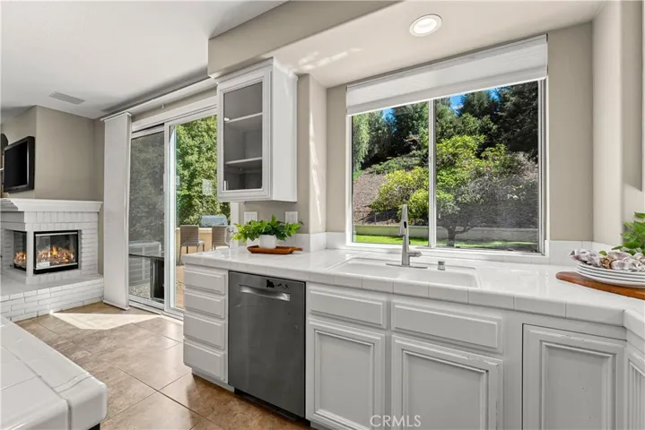 Kitchen is open to the family room and breakfast nook. Fire has been digitally added to fireplace