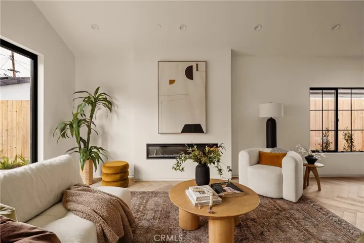 Cozy color-changing electric fireplace pre-wired with electrical outlets above it for TV and entertainment systems