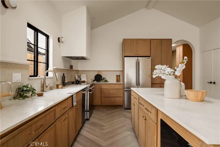 Chef's kitchen with top-tier appliances, natural oak cabinets and marble countertops