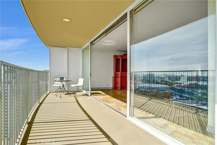 Floor-to-ceiling glass doors stretch across the living area, opening completely to the balcony for effortless entertaining and stunning views.