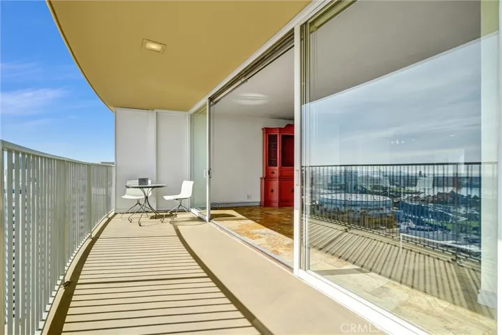 Floor-to-ceiling glass doors stretch across the living area, opening completely to the balcony for effortless entertaining and stunning views.