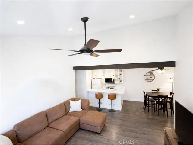 Living room with high vaulted ceilings, recessed lighting, and an open flow to the kitchen and dining area.