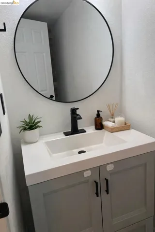 Bathroom with a textured wall and vanity