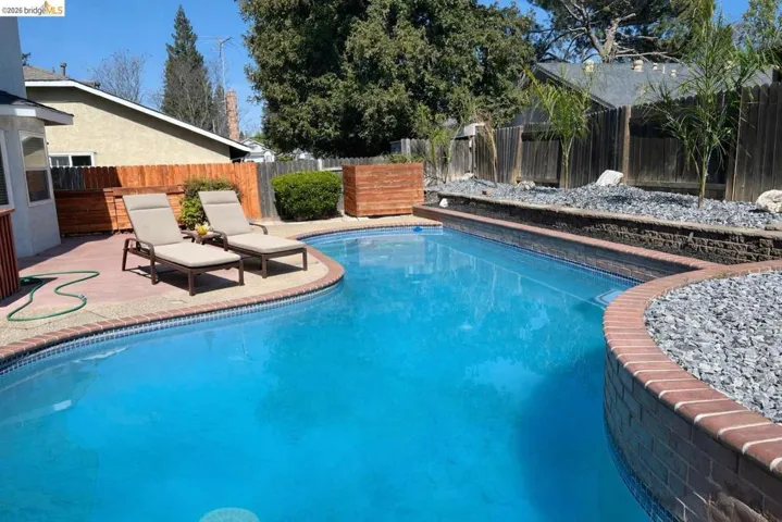 View of swimming pool with a fenced backyard and patio surround