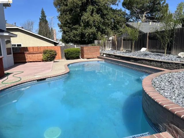 View of pool featuring a fenced backyard and patio surround