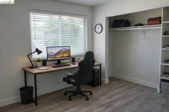 Office space with light wood-type flooring and a textured wall