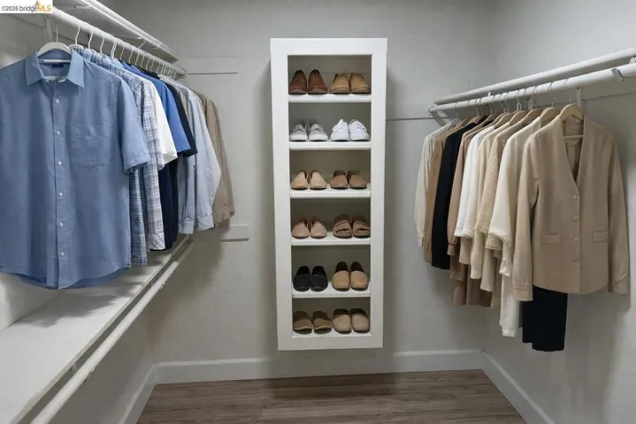 Walk in closet with wood finished floors