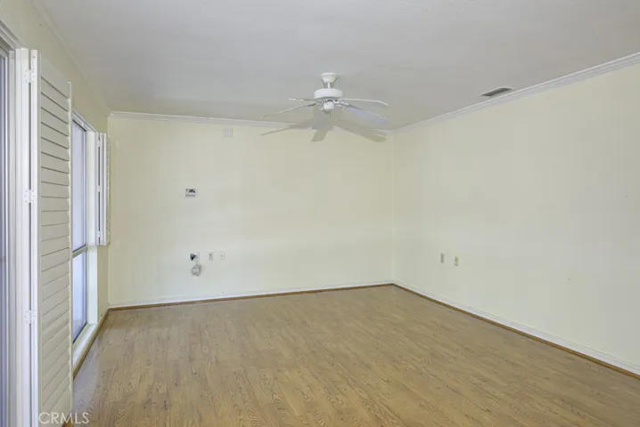 Another view of the large living room. Upgraded features throughout the residence include a ceiling fan in the living room, central heat and air and plantation shutters.