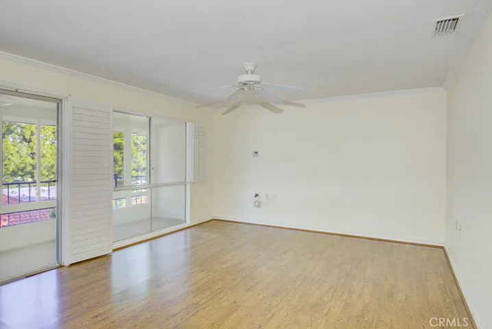 Living room has large windows looking onto the balcony and the tree-filled view beyond.