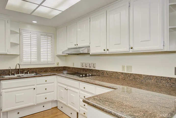 The kitchen features granite countertops, stainless steel appliances and ample storage cabinets.