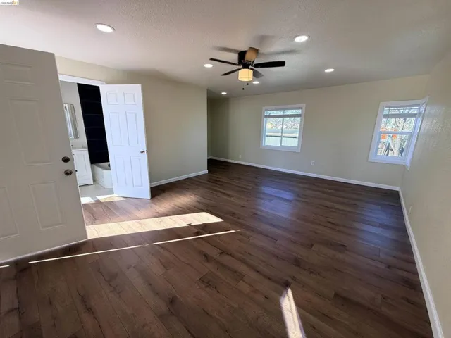 Spare room featuring dark wood finished floors, a ceiling fan, a textured ceiling, and recessed lighting