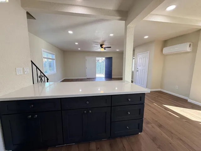 Kitchen featuring open floor plan, dark wood finished floors, dark cabinetry, a textured ceiling, and recessed lighting