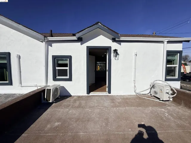 View of exterior entry featuring stucco siding and a patio area