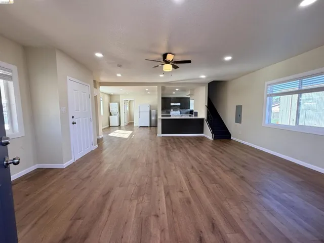 Unfurnished living room with recessed lighting, dark wood-style floors, a ceiling fan, electric panel, and washer / dryer