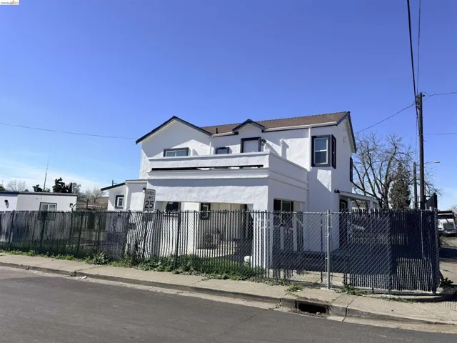 View of front of home with stucco siding and a fenced front yard