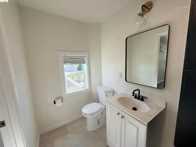 Bathroom featuring vanity, a textured wall, and light tile patterned floors
