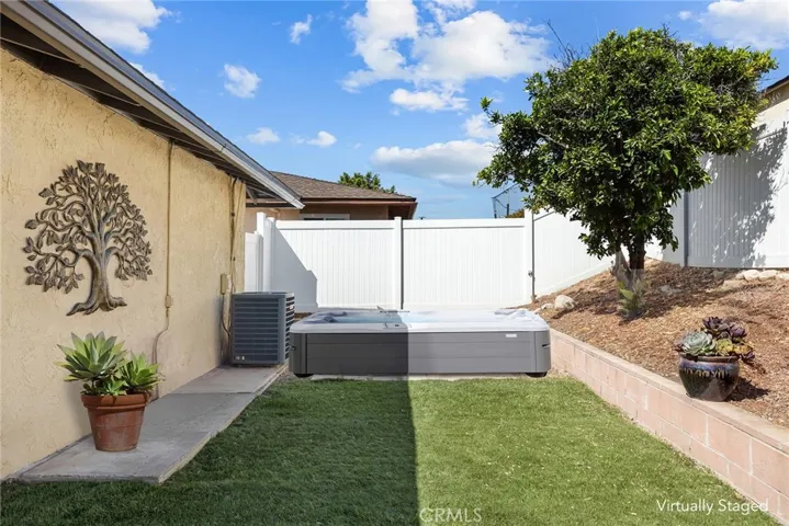 West end of back yard with virtually staged hot tub.
