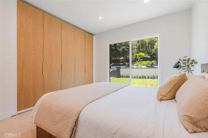 Bedroom with custom wood wardrobe wall and modern finishes.