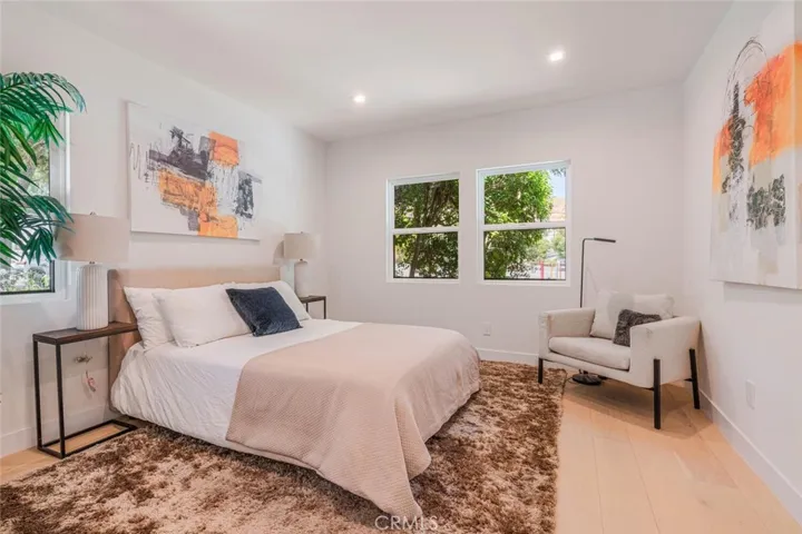 Guest bedroom with large windows and abundant natural light.