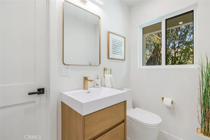 Remodeled hallway bathroom with modern vanity and window for natural light.