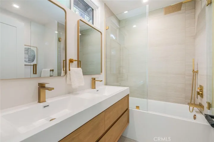 Updated primary bathroom with dual vanity, soaking tub, and modern fixtures.