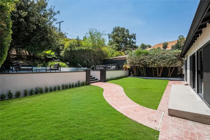 Backyard view highlighting the grassy yard and indoor-outdoor flow.