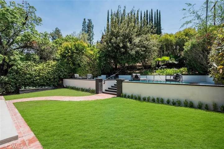 Private backyard with lush lawn, pool, and mature landscaping — perfect for indoor-outdoor California living.