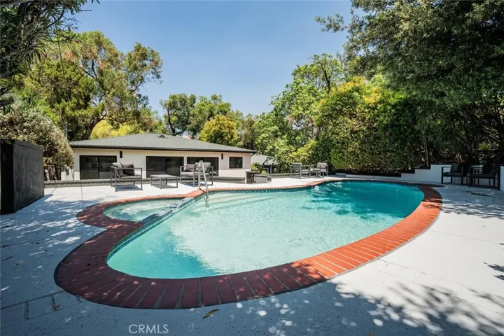 Wide view of the pool and backyard creating a resort-style atmosphere.